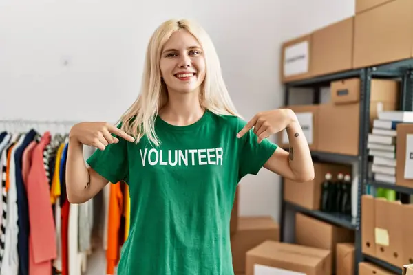 Νεαρή Ξανθιά Γυναίκα Δείχνει Εθελοντής Πουκάμισο Χαμογελώντας Φιλανθρωπικό Κέντρο — Φωτογραφία Αρχείου