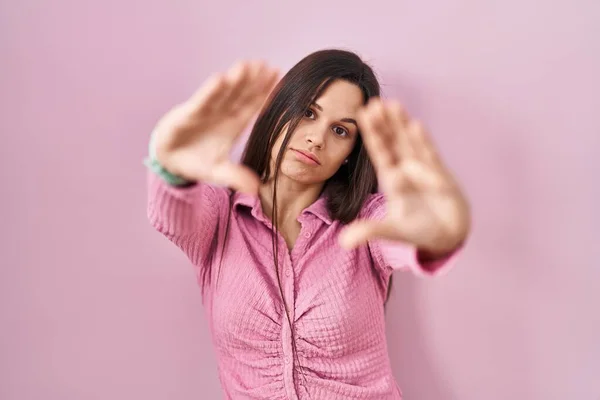 Pembe Arka Planda Duran Genç Spanyol Kadın Parmaklarıyla Çerçeve Yapıyor — Stok fotoğraf