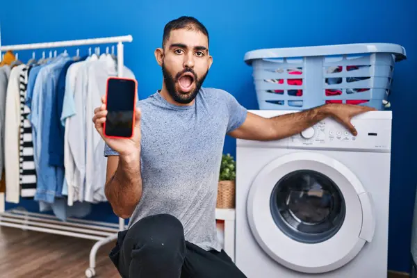 Mellanösternman Med Skägg Visar Smartphone Skärm Och Tvättmaskin Chockansikte Ser — Stockfoto