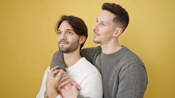 stock image Two men couple hugging each other standing with relaxed expression over isolated yellow background