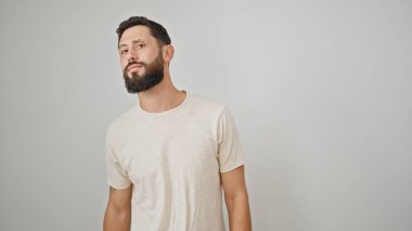 Soyutlanmış beyaz bir arka planda ciddi bir ifade arayan İspanyol bir genç.