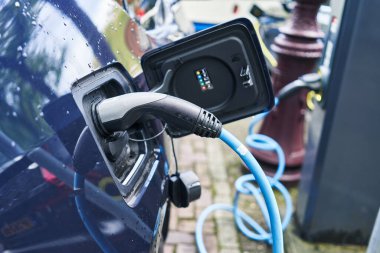 Elektrikli araba sokakta şarj oluyor.