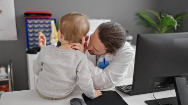Baba oğul klinikte kulak muayenesi yapan doktor.