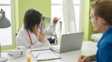 Doktor klinikteki hastaya röntgen gösteriyor.