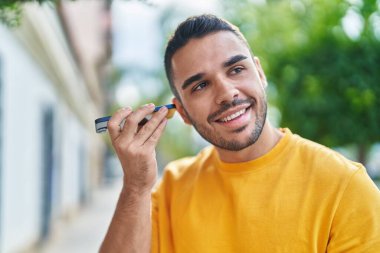 Genç İspanyol adam gülümsüyor. Caddedeki akıllı telefondan kendine güvenen bir sesli mesaj dinliyor.