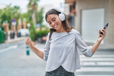 Sokak ortasında müzik dinleyen ve dans eden genç, güzel İspanyol kadın.