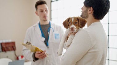 Veteriner kliniğinde danışmanlık yapan iki adam.