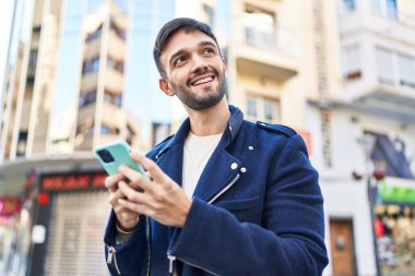 Sokakta akıllı telefon kullanan, kendine güvenen genç bir İspanyol.