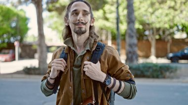 Sırt çantası takan İspanyol genç turist parkta rahatlamış.