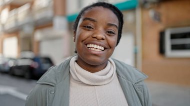 Sokakta kendine güvenen Afrikalı Amerikalı kadın gülümsüyor