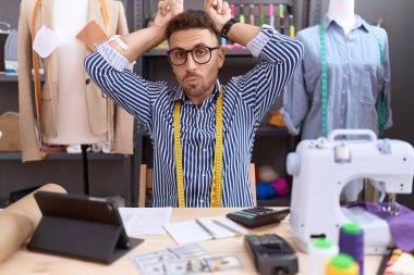 Sakal terzisi olan İspanyol bir adam Atölye 'de çalışıyor. Parmağını boynuzlarına geçirip komik jestler yapıyor. 