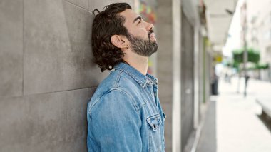 Duvara yaslanan genç bir İspanyol sokakta stresli.