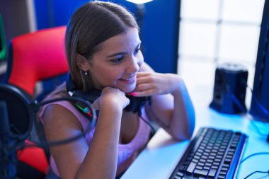 Genç, güzel İspanyol kadın, gülümseyen, kendine güvenen, oyun masasında oturan.