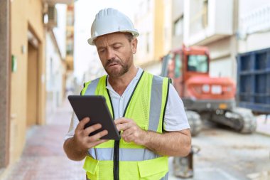 Middle age man architect using touchpad at street