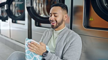 Çamaşırhanede yerde oturmuş bez kokusu alan genç bir İspanyol.