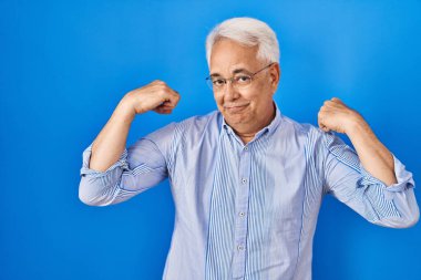 Kollarında gururla gülümseyen, gözlüklü İspanyol kıdemli adam. fitness konsepti. 