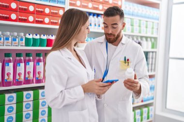 Eczanede dokunmatik ped kullanan erkek ve kadın eczacılar.