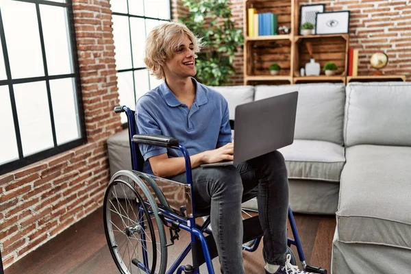 Mladý Blondýnka Muž Pomocí Notebooku Sedí Invalidním Vozíku Doma — Stock fotografie