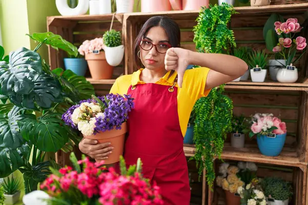 Νεαρή Γυναίκα Άραβας Που Εργάζεται Στο Ανθοπωλείο Κρατώντας Φυτό Θυμωμένο — Φωτογραφία Αρχείου
