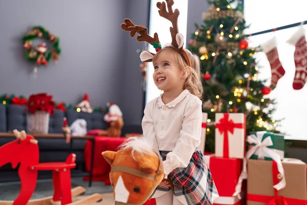 Adorable Blonde Girl Playing Horse Toy Standing Christmas Tree Home — Stock Photo, Image