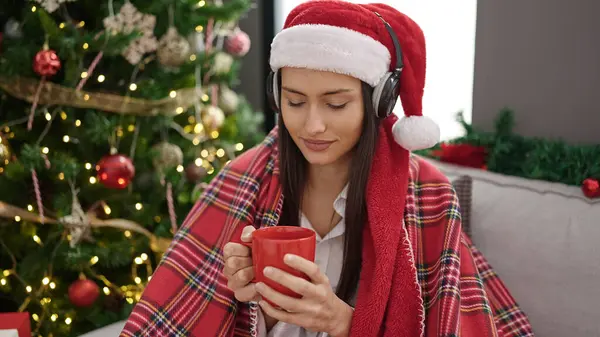 年轻美丽的惊慌失措的女人听着音乐喝咖啡庆祝圣诞节 — 图库照片