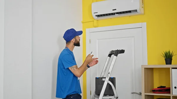 Junger Spanischer Mann Repariert Klimaanlage Mit Fernbedienung Hause — Stockfoto