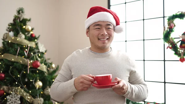 Νεαρός Κινέζος Πίνει Καφέ Δίπλα Στο Χριστουγεννιάτικο Δέντρο Στο Σπίτι — Φωτογραφία Αρχείου
