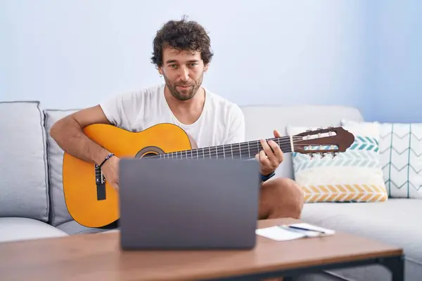Młody Latynos Człowiek Mając Online Klasę Gitara Klasyczna Siedzi Kanapie — Zdjęcie stockowe