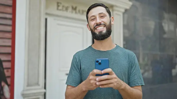 Молодий Іспаномовний Чоловік Використовує Смартфон Посміхаючись Вулиці — стокове фото