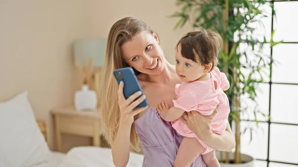 Madre Hija Abrazándose Entre Usando Teléfono Inteligente Dormitorio — Foto de Stock