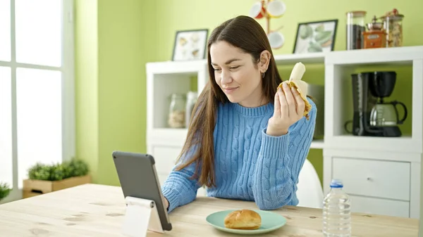 Young Caucasian Woman Eating Banana Using Touchpad Dinning Room — Stock Photo, Image