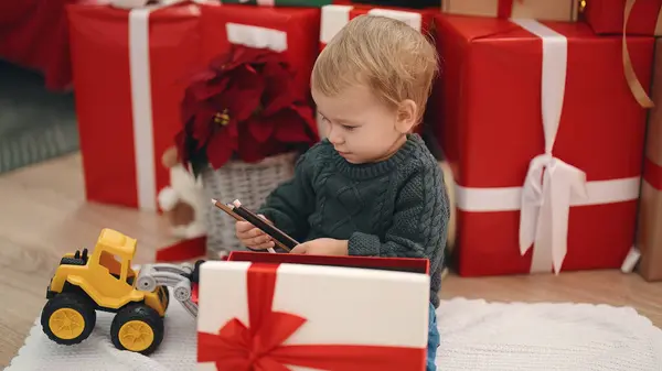 Sevimli Sarışın Bebek Evde Oturmuş Noel Hediyesini Açıyor — Stok fotoğraf