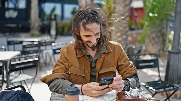 年轻的他的惊慌失措的游客坐在咖啡店阳台的桌子上 用智能手机 — 图库照片