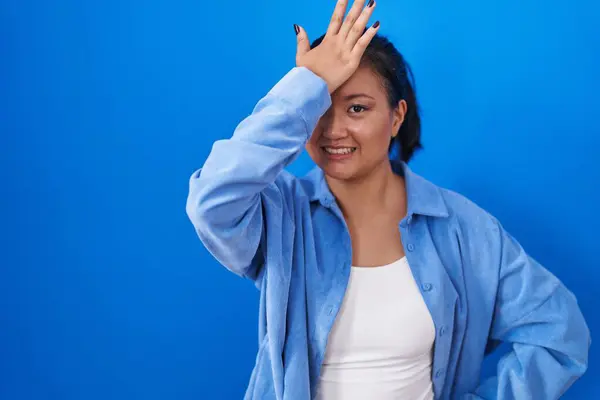 Asiática Jovem Mulher Sobre Fundo Azul Surpreso Com Mão Cabeça — Fotografia de Stock