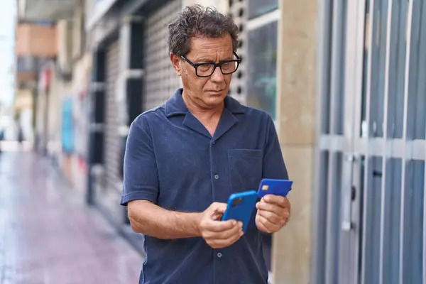 Sokaklarda Akıllı Telefon Kredi Kartı Kullanan Orta Yaşlı Bir Adam — Stok fotoğraf