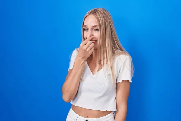 Young Caucasian Woman Standing Blue Background Smelling Something Stinky Disgusting — Fotografia de Stock