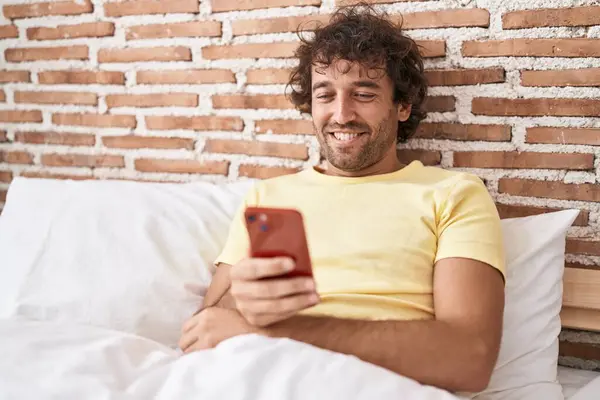 Hispanic Young Man Using Smartphone Bed Looking Positive Happy Standing — Stock Photo, Image