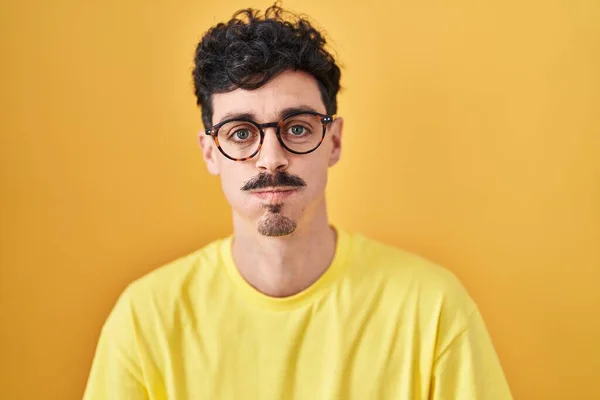 Hispanic Man Bär Glasögon Stående Över Gul Bakgrund Puffande Kinder — Stockfoto