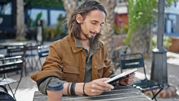 Young Hispanic Man Reading Book Sitting Table Coffee Shop Terrace —  Fotos de Stock