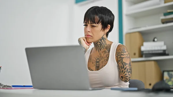 在办公室里用笔记本电脑思考截肢的西班牙妇女 — 图库照片