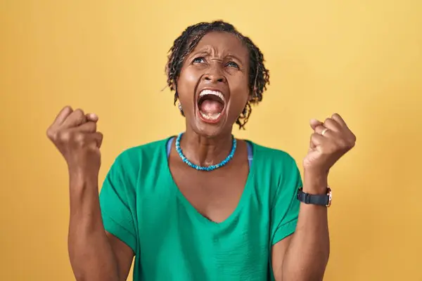 Африканская Женщина Дредами Стоящая Жёлтом Фоне Злая Безумная Кричащая Расстроенная — стоковое фото