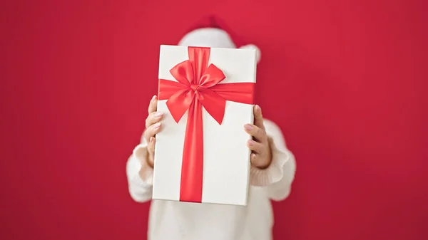孤立した赤い背景上のクリスマスの贈り物を保持している若い金髪の女性 — ストック写真