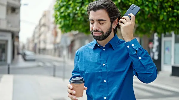 Joven Hispano Escuchando Mensaje Voz Smartphone Bebiendo Café Calle — Foto de Stock