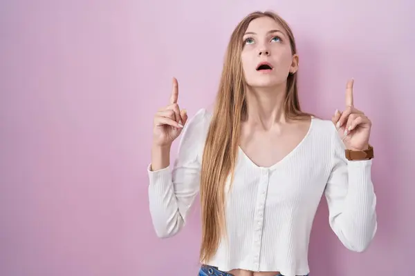 Young Caucasian Woman Standing Pink Background Amazed Surprised Looking Pointing — Stock fotografie