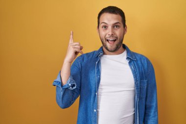 Sarı arka planda duran İspanyol adam başarılı bir fikir işaret ediyor. Heyecanlı ve mutlu. Bir numara.. 