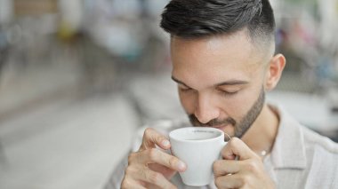 Genç İspanyol adam kahve dükkanının terasında çay kokusu alıyor.