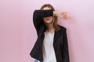 Siyah ceketli, kollarıyla gözlerini kapatan, ciddi ve üzgün görünen beyaz bir iş kadını. Görme, saklama ve reddetme konsepti 