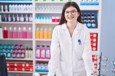 Young caucasian woman pharmacist smiling confident standing at pharmacy