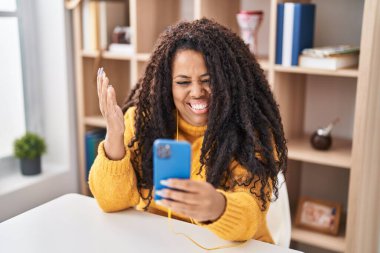 Ayrıca akıllı telefon kullanan İspanyol kadın başarıyı mutlu bir gülümsemeyle kutluyor ve kazanan el kaldırarak ifade ediyor. 