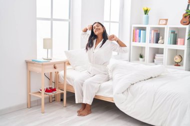 Genç, güzel İspanyol bir kadın yatak odasında kollarını açarak uyanıyor.